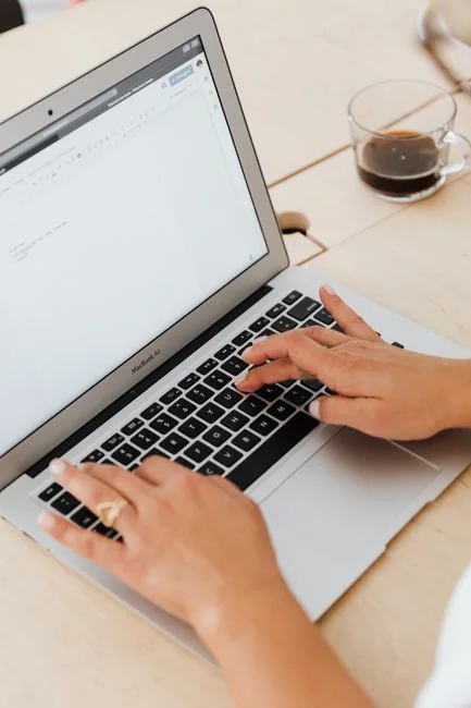 Close-up of a woman working on a digital marketing project in a home office setting.